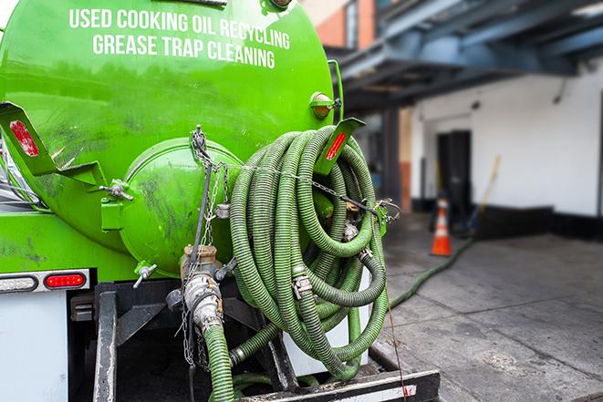 a grease trap pumping service in action at a commercial building in Augusta, WI